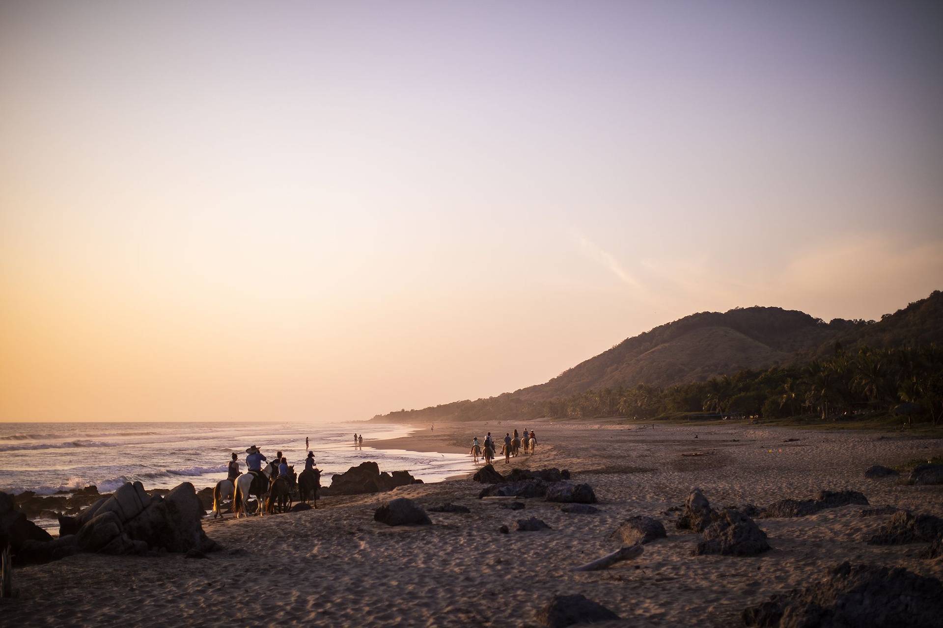 one of the best surf retreats around the world-present-moment-retreat-sunset-beach-horseback-riding